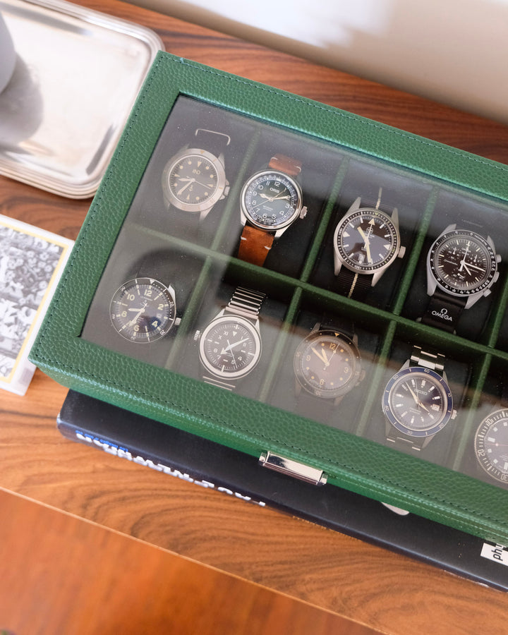 boite à montre verte avec dessus vitré transparent et emplacements pour montres. Vue de dessus